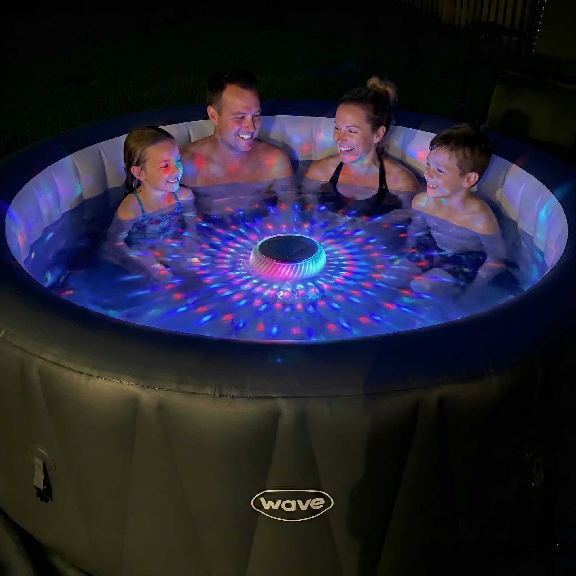 Family of 4 in a Wave spa with a floating pool light